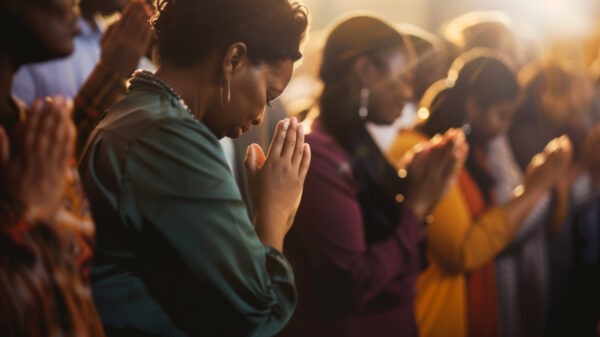 A group of people standing in prayer during a worship service